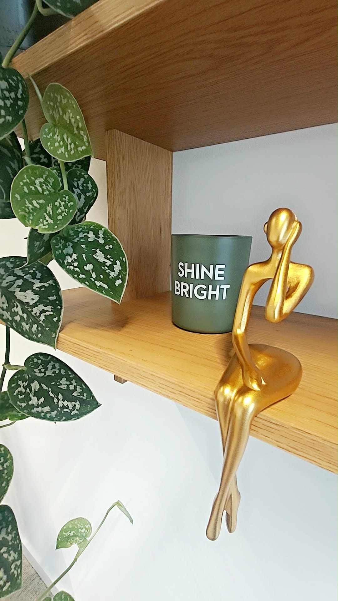 Détail décoratif : figurine dorée et bougie « Shine Bright »